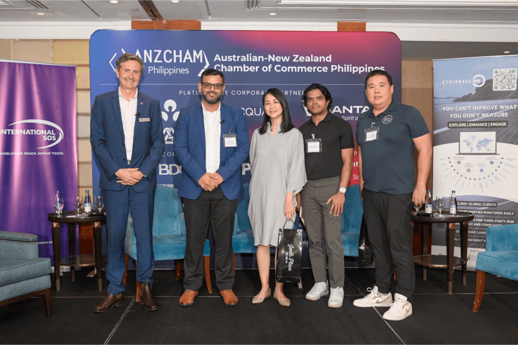 Six guests standing in front of an ANZCHAM Philippines banner in a function room